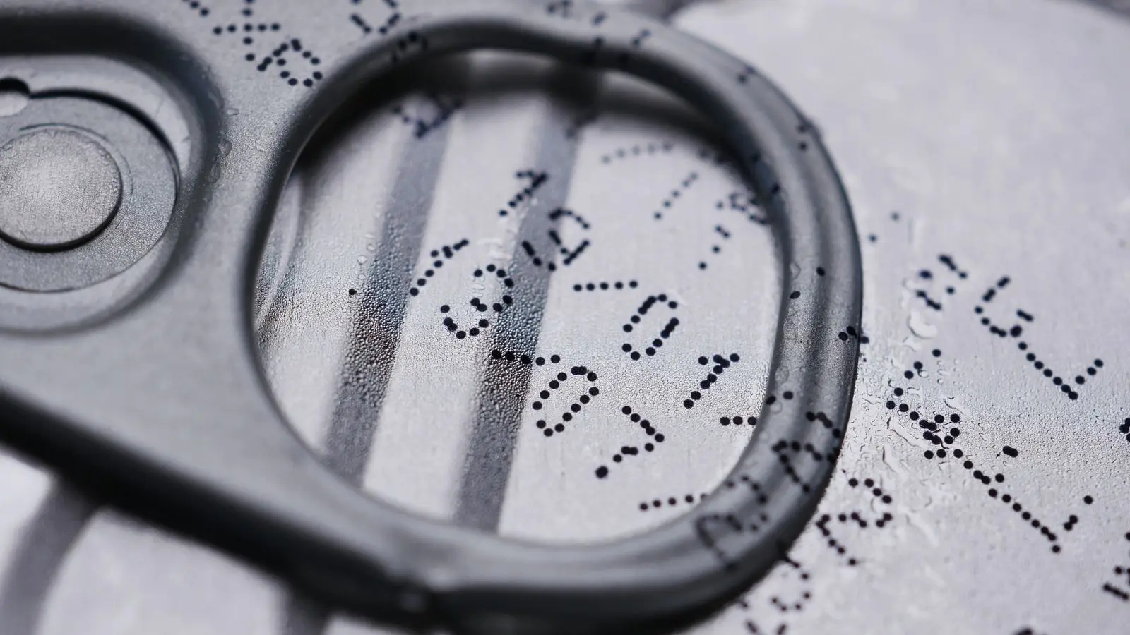 Close-up of a can lid with a printed date code under the pull tab