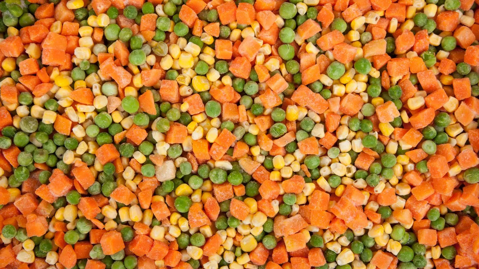 Close-up of frosty frozen mixed vegetables: diced carrots, peas and corn